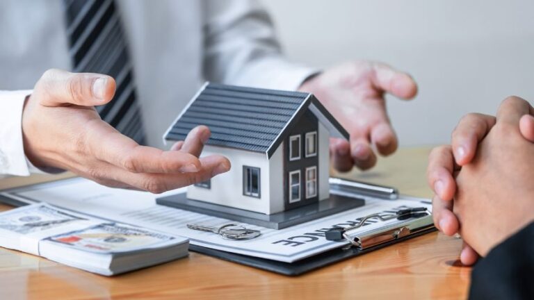Agent nieruchomości prezentuje model domu i kredyt